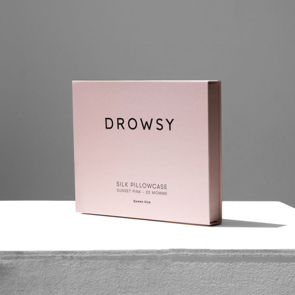 Pink packaging box for a silk pillowcase on a neutral background