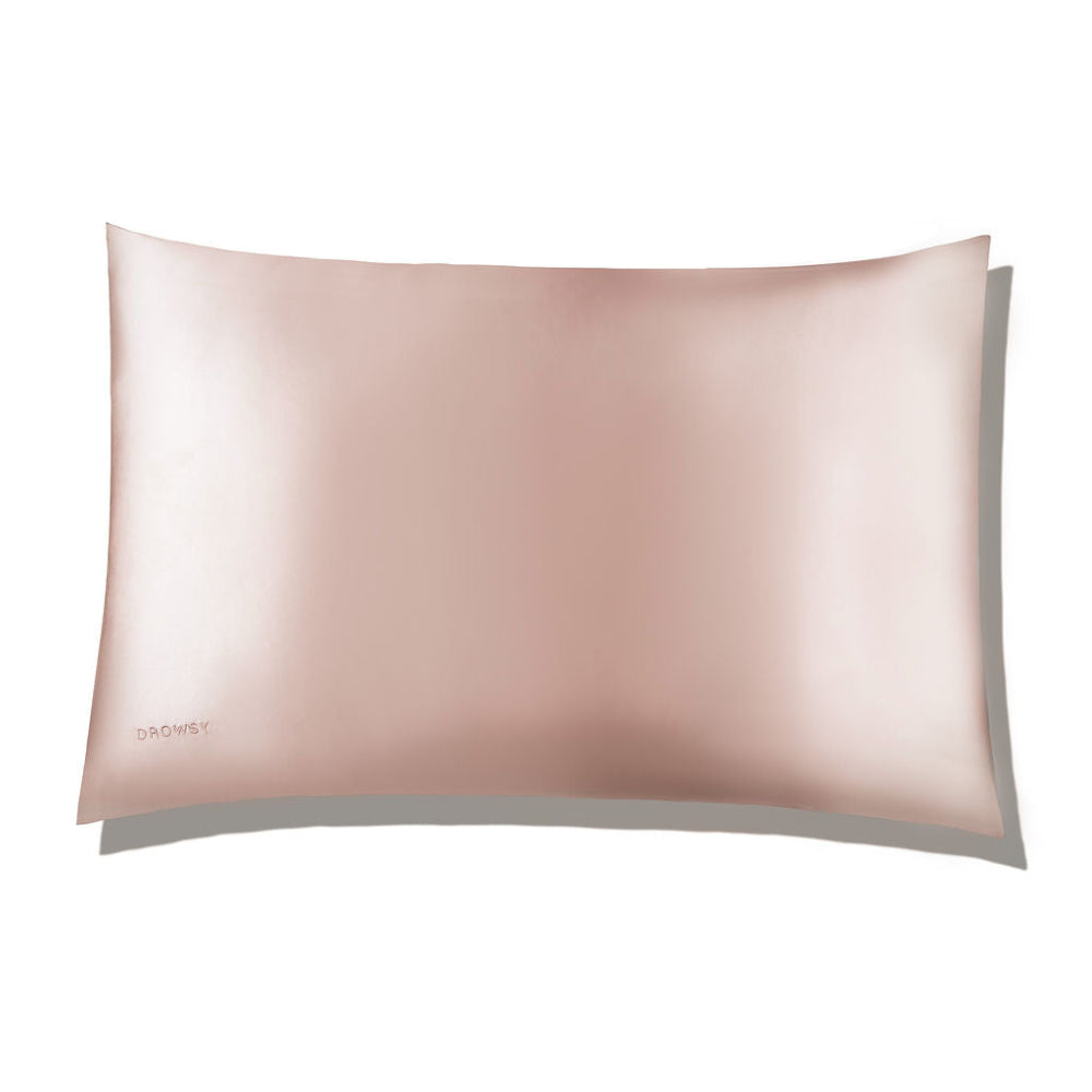 A soft pink silk pillowcase with a subtle sheen, displaying the brand name 'Drowsy' on the bottom right corner.