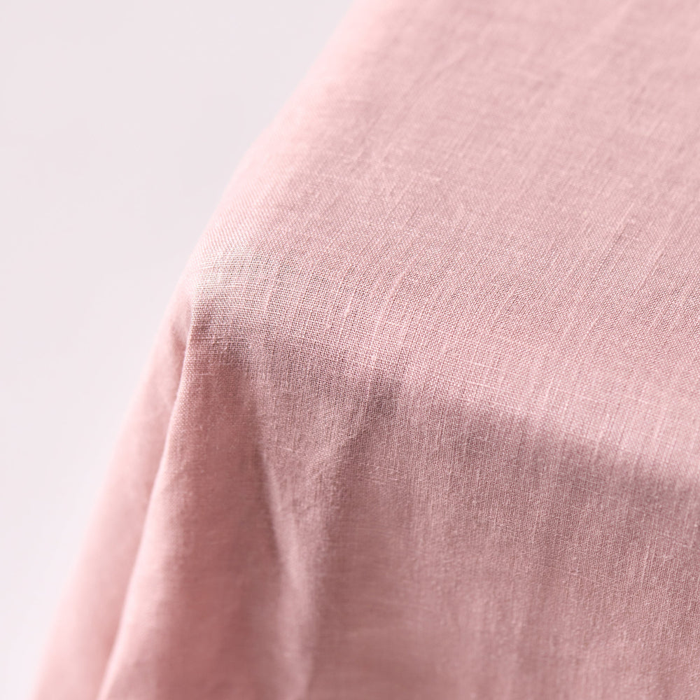 Close-up of a pink fabric texture on a light gray background