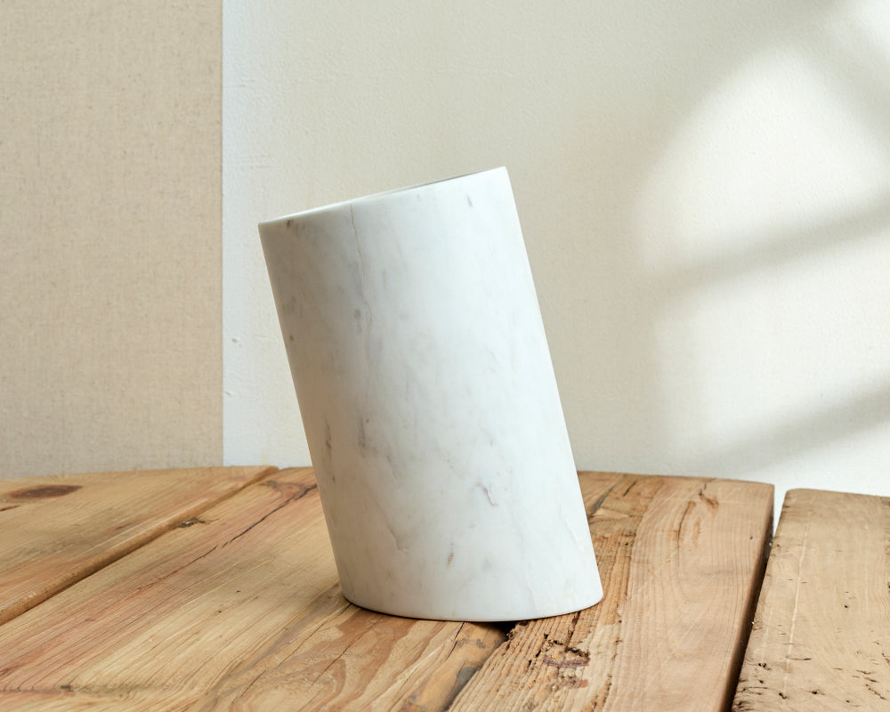 White marble vase on a wooden surface with a neutral background