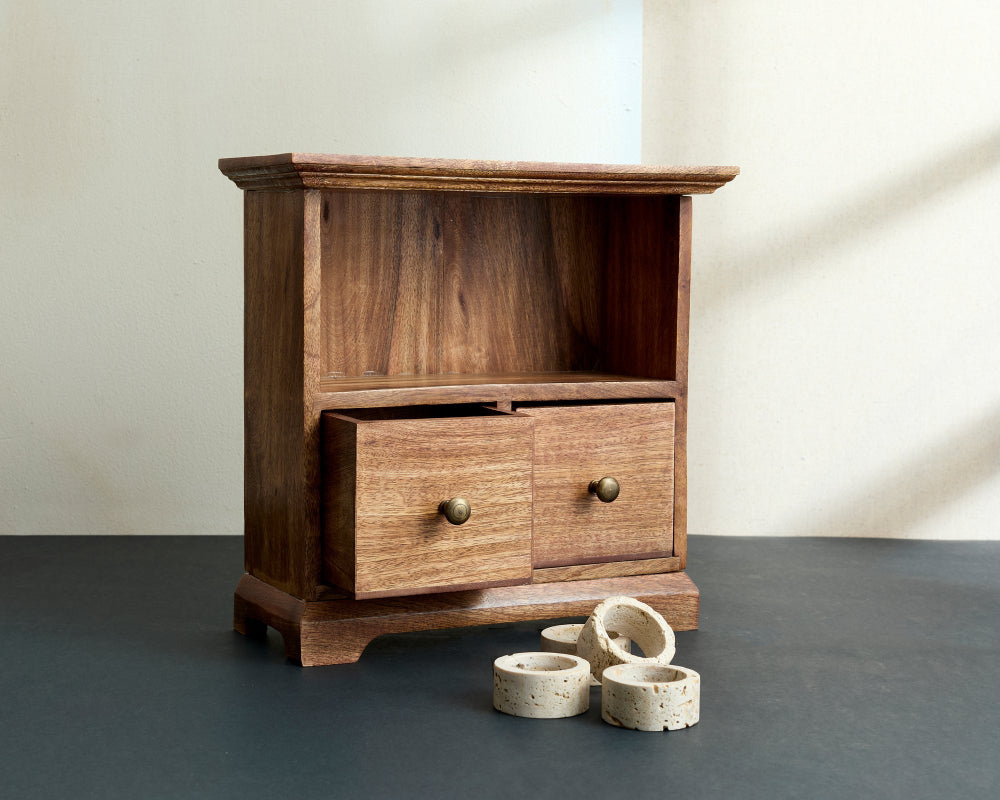 Wooden cabinet with a drawer and three ceramic bowls on a grey floor.