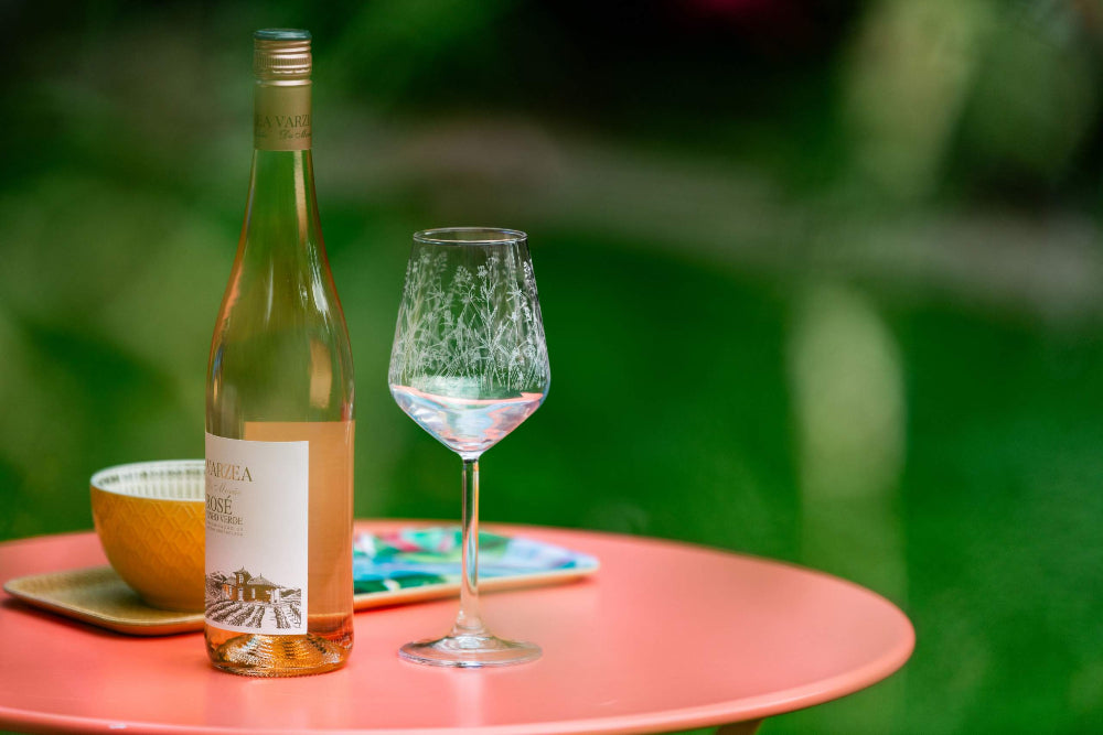 Wine bottle and glass on a table with a blurred green background