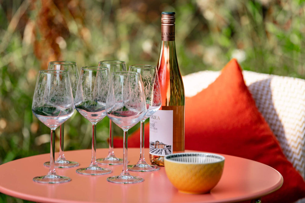 Wine bottle and glasses on a table with a blurred natural background