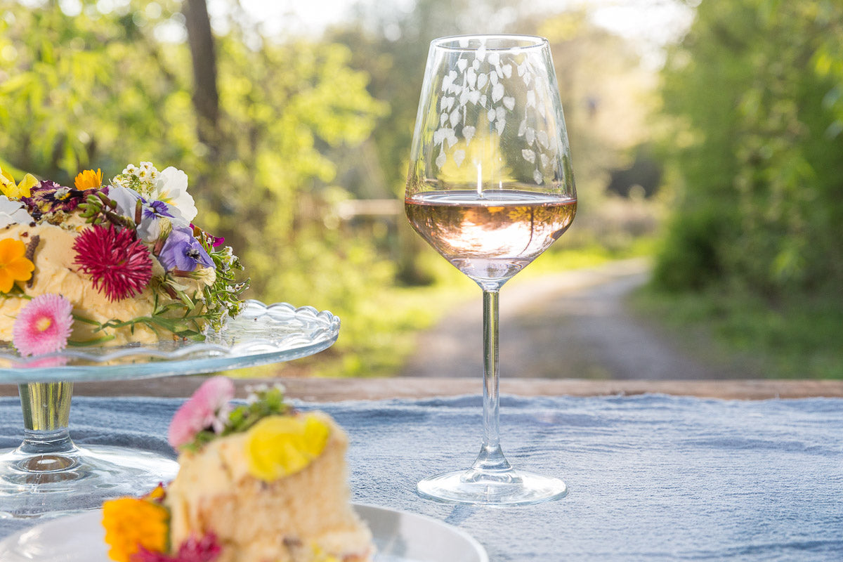 Glass of white wine on a table with floral decorations outdoors