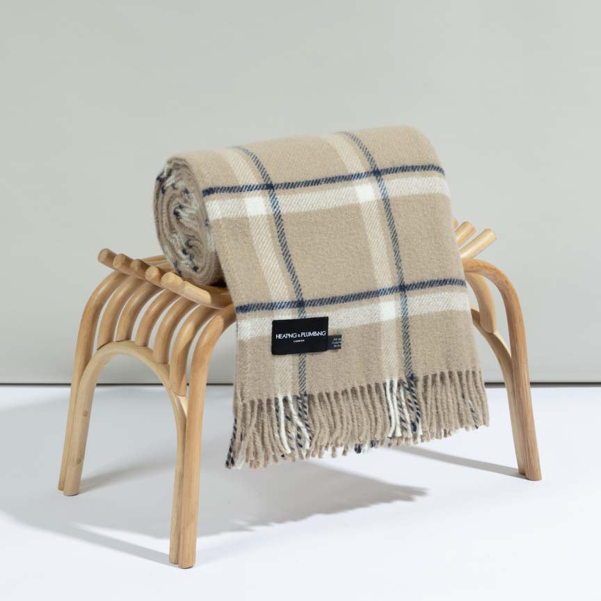 Plaid blanket draped over a wooden chair on a white background