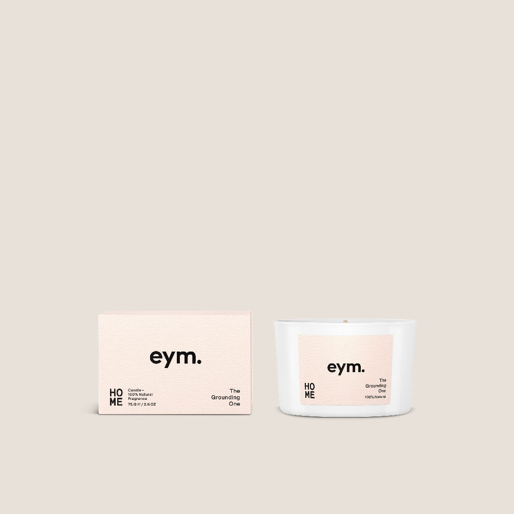 Candle called 'Home' with 'eym.' branding and box packaging on a light beige background