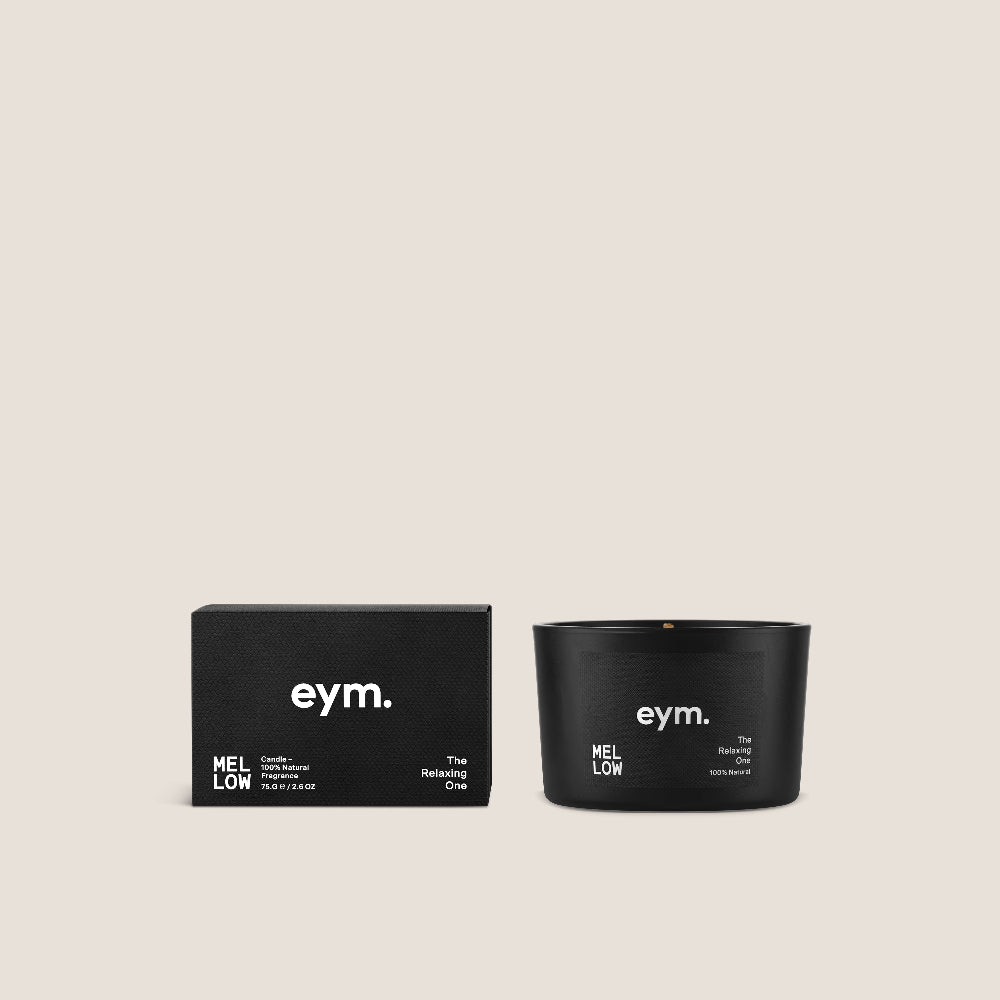Black candle and packaging with 'eym.' branding on a beige background