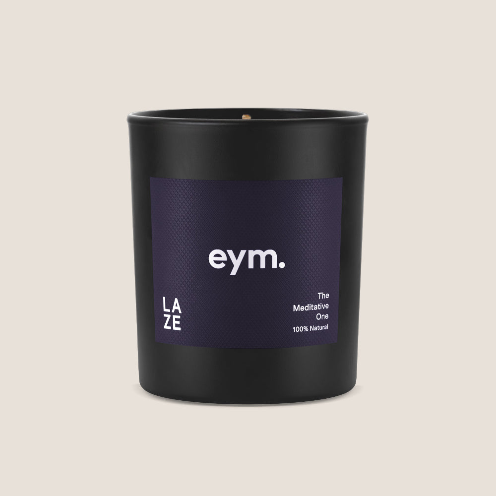 Black candle vessel with a purple label featuring 'eym' on a beige background