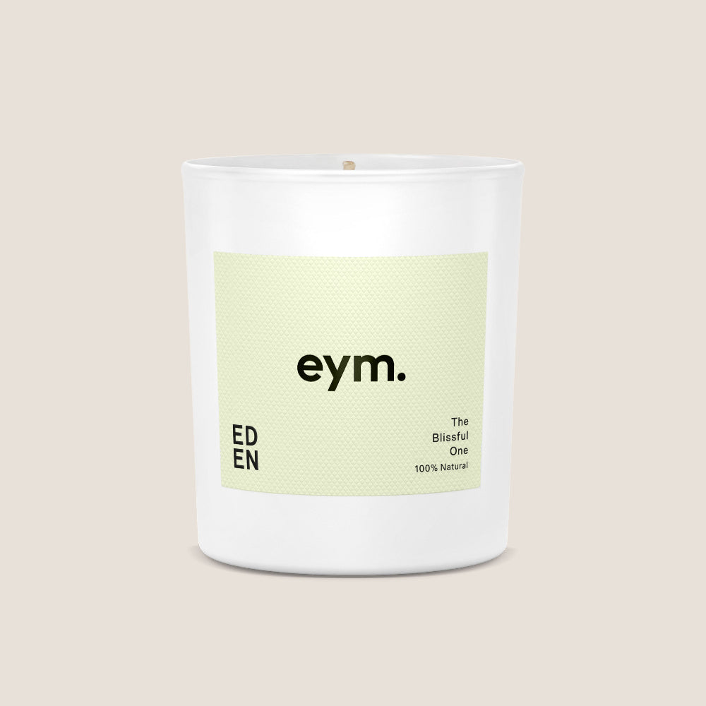 White candle with a green label on a beige background