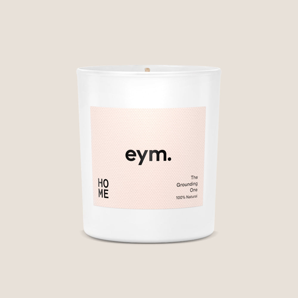 White Candle with a pink 'eym.' label on a beige background.