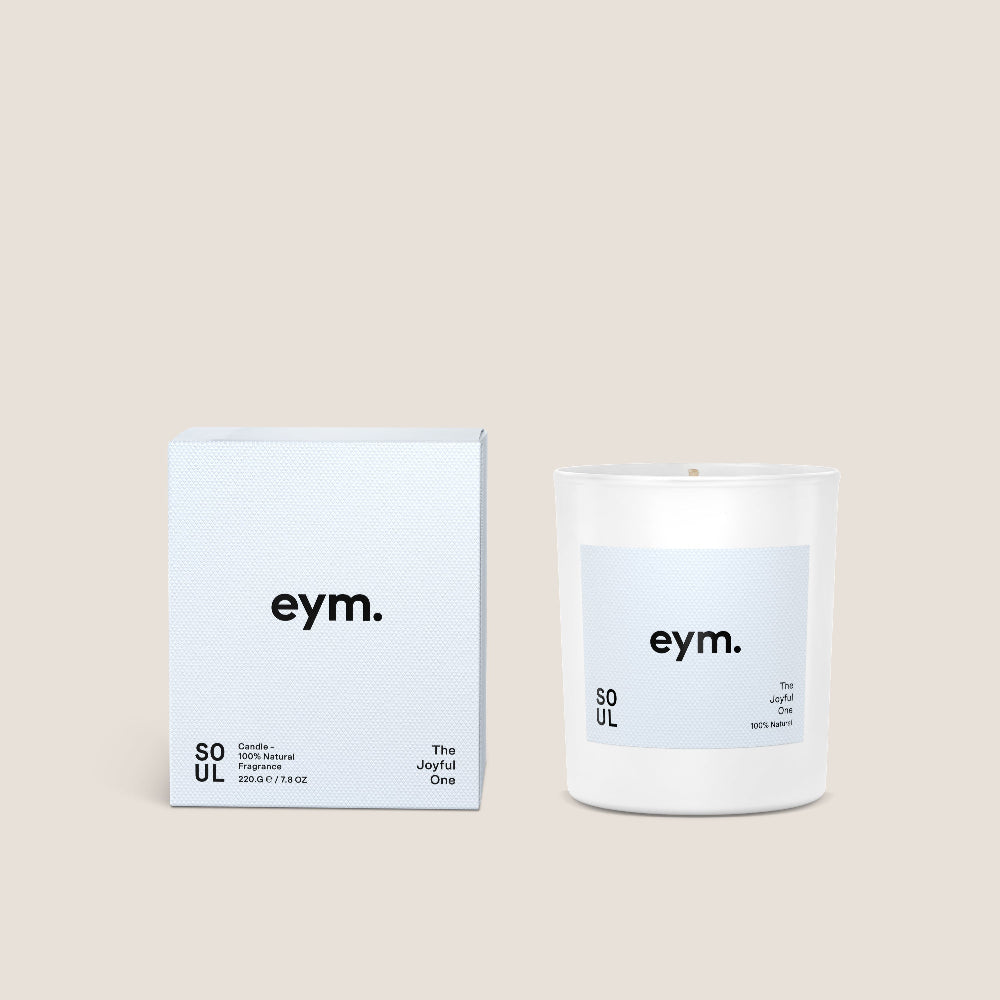 White Candle and packaging with 'eym.' branding on a beige background
