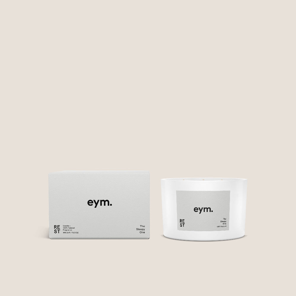 Three wick Candle called 'Rest' and packaging with 'eym.' branding on a beige background