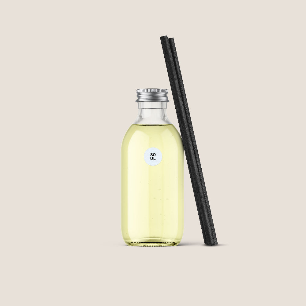 Eym Diffuser 'Soul' refill in a Clear bottle with yellow liquid and black reeds on a beige background