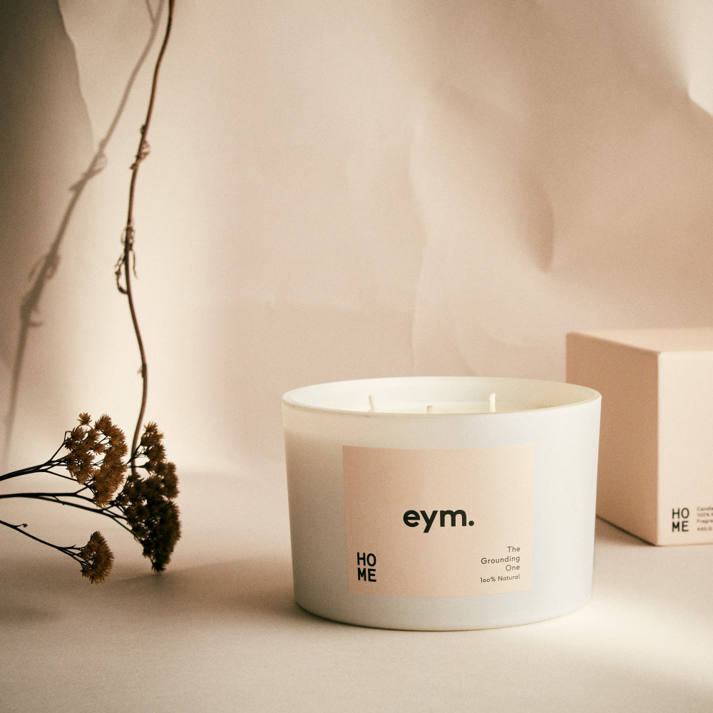 Eym Natural Three wick White candle with 'eym.' label on a beige background. The Grounding one.