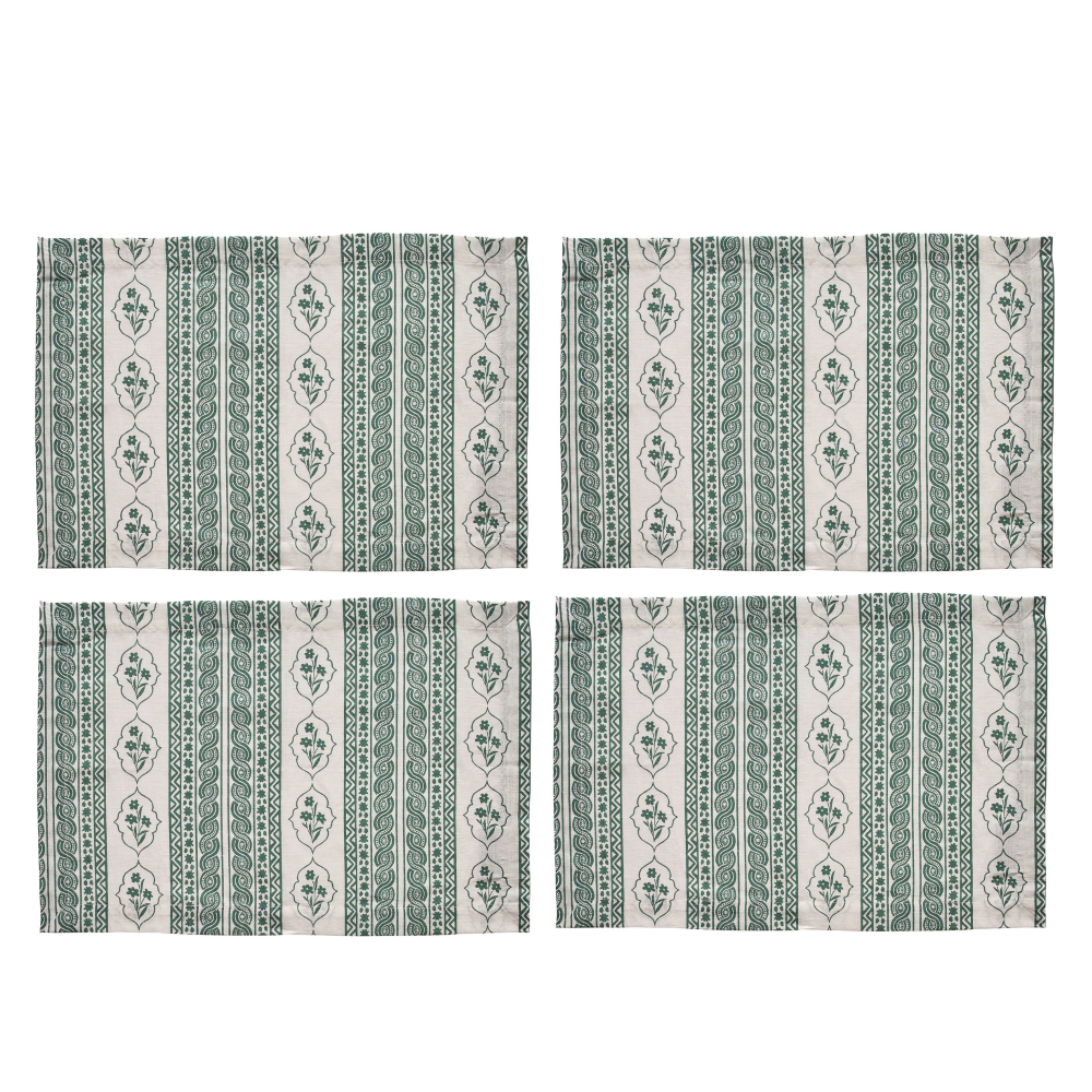 Set of four green and white patterned placemats on a white background