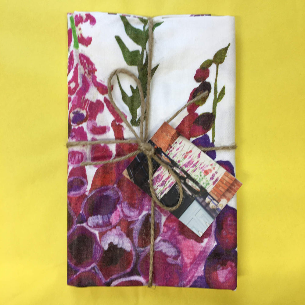 Foxglove Tea Towel tied with twine on a yellow background