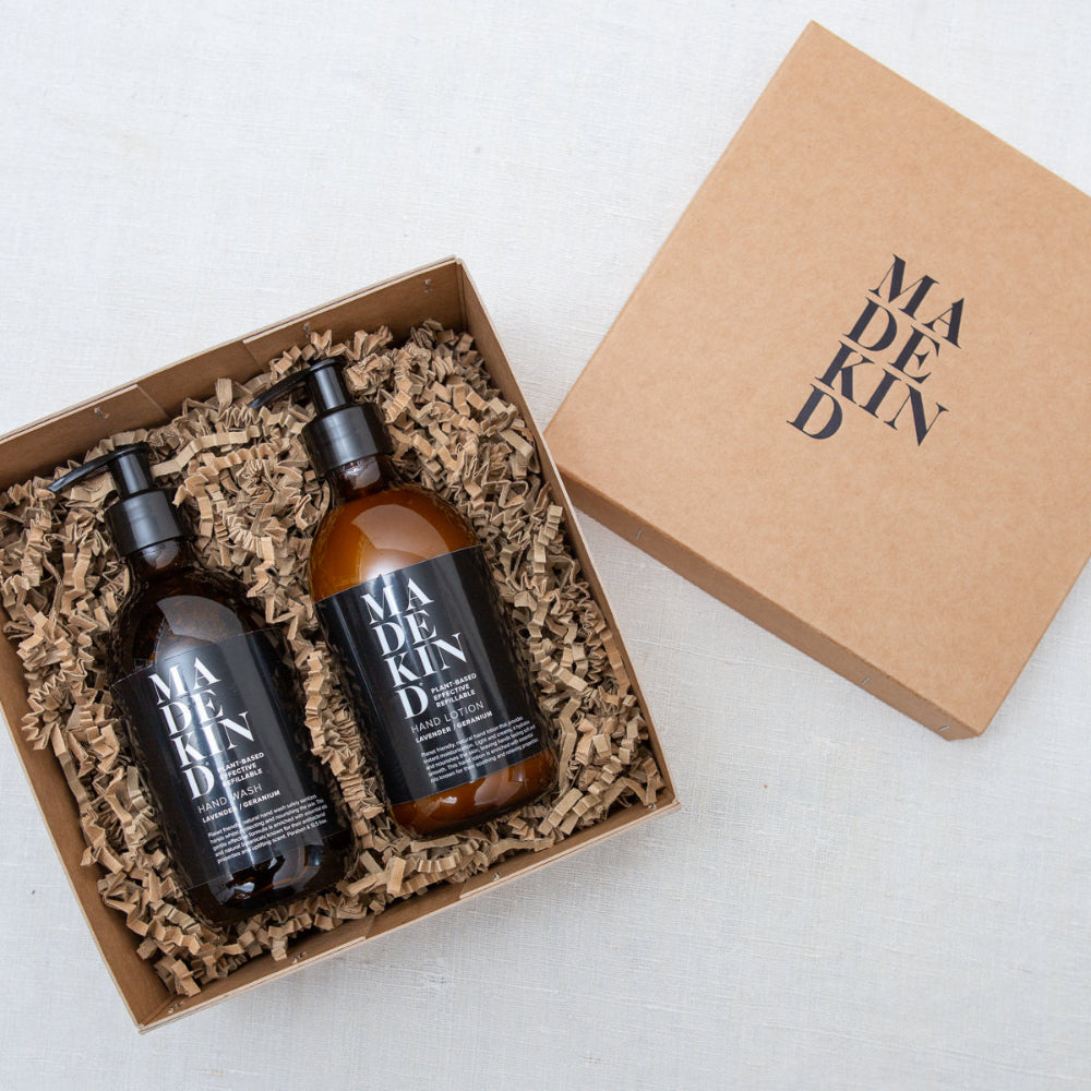 Two bottles of 'MADEKIND' products in a cardboard box on a light background