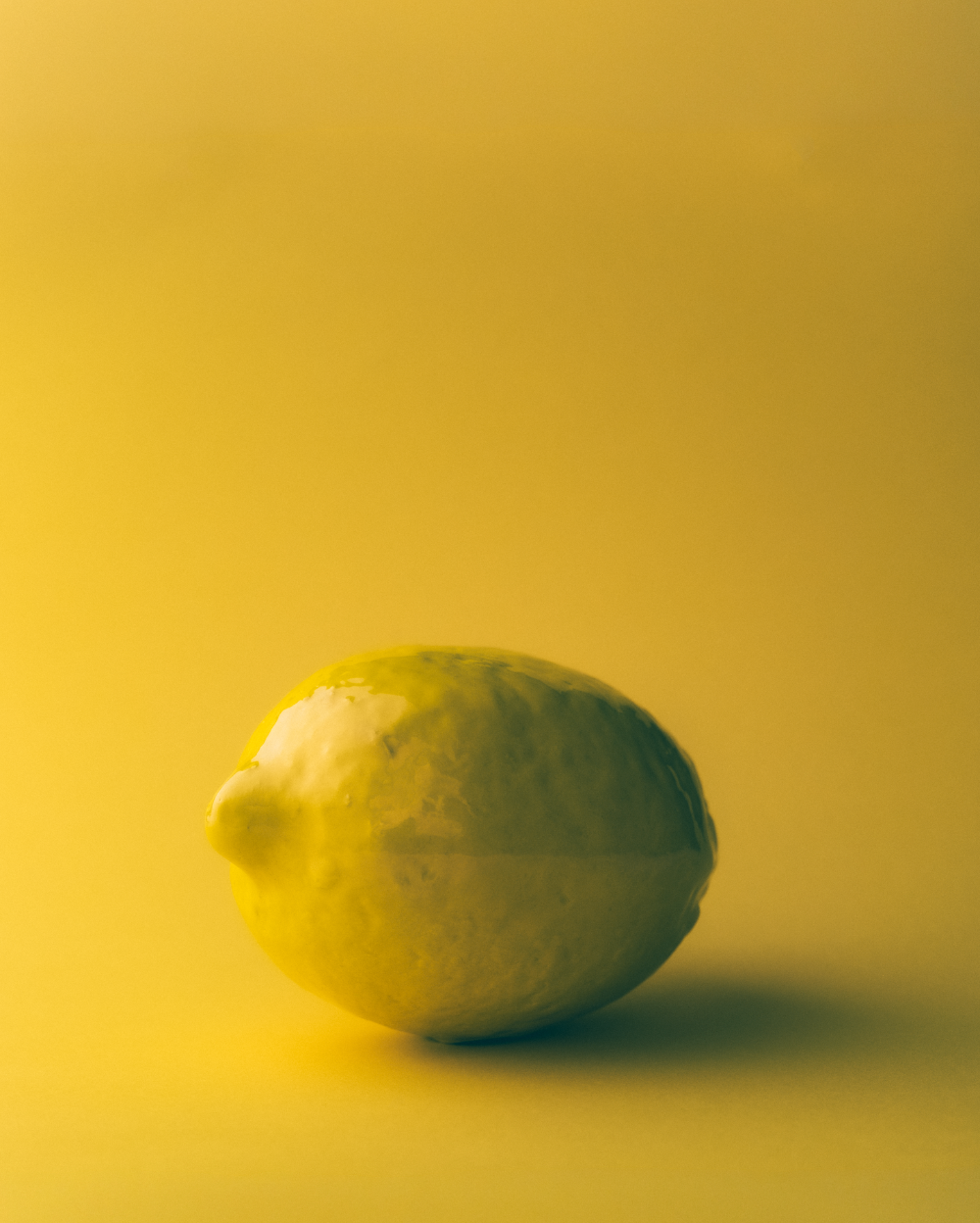 Handmade ceramic glazed lemon on a yellow background