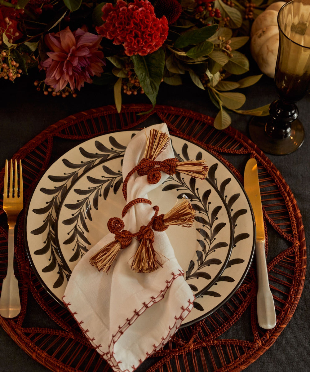 Helecho Ceramic Dinner Plate on a red charger and flowers on a dinner table setting