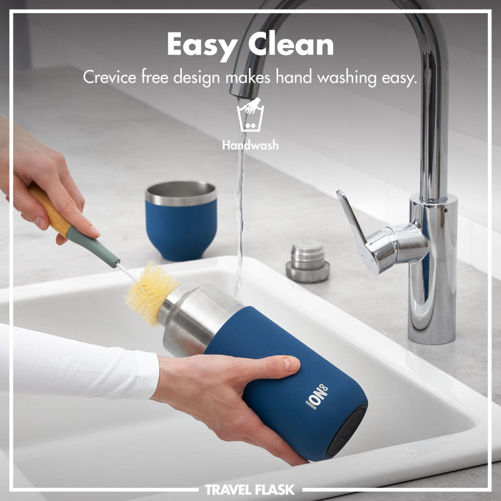 Blue travel flask being cleaned with a brush in a sink, with text indicating easy cleaning design.