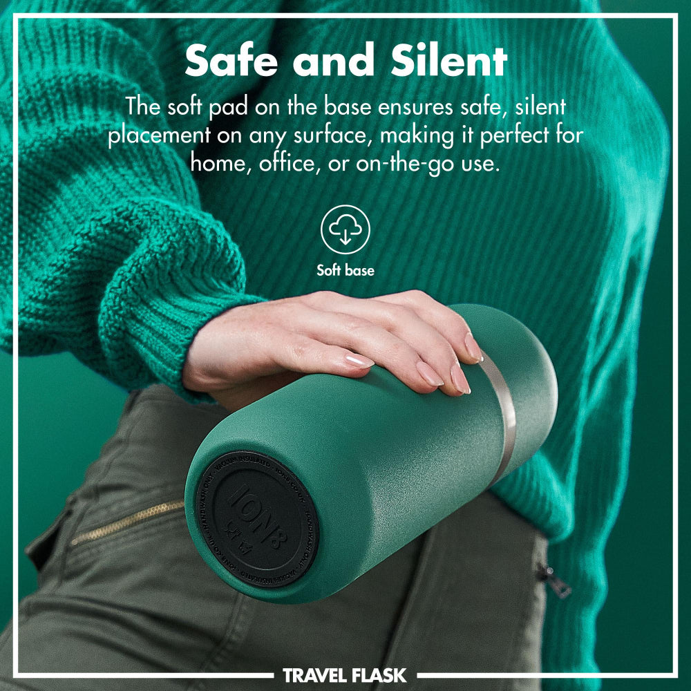 Person holding a green travel flask with text about its safe and silent design.