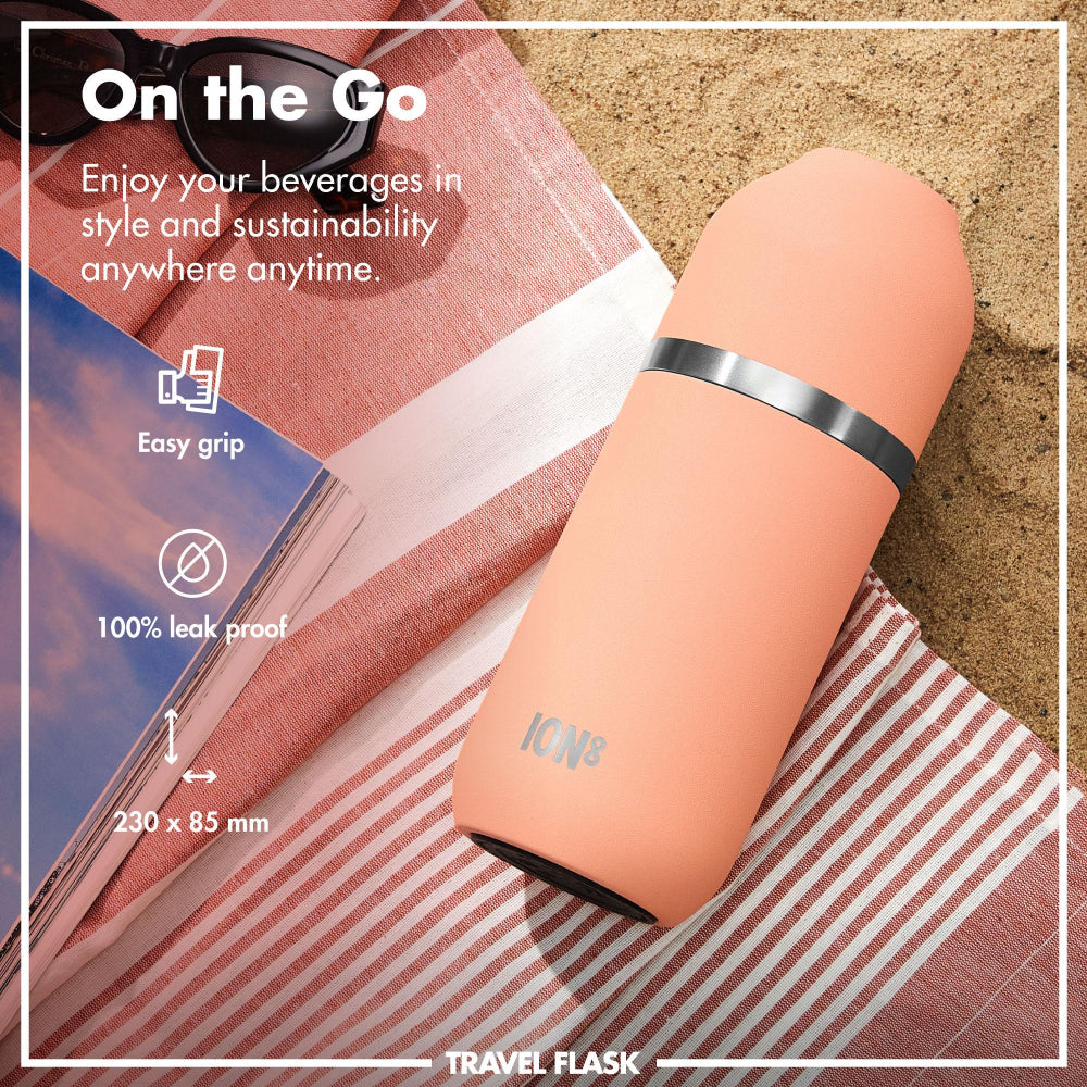 Travel flask on a beach towel with promotional text about its features.
