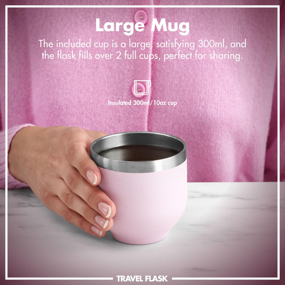 Person holding a pink insulated travel mug with text about its capacity and use.