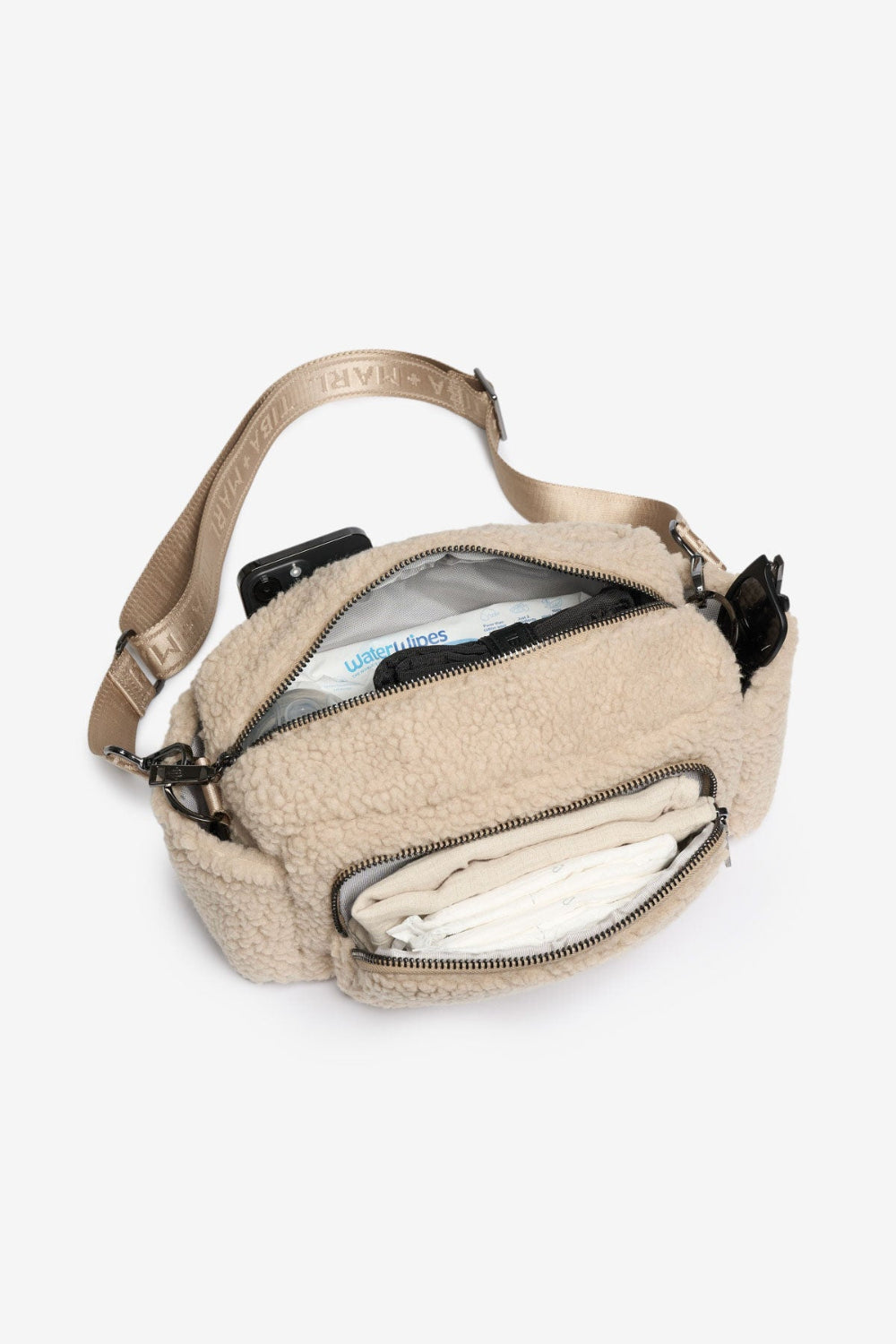 Beige crossbody bag with multiple compartments on a white background