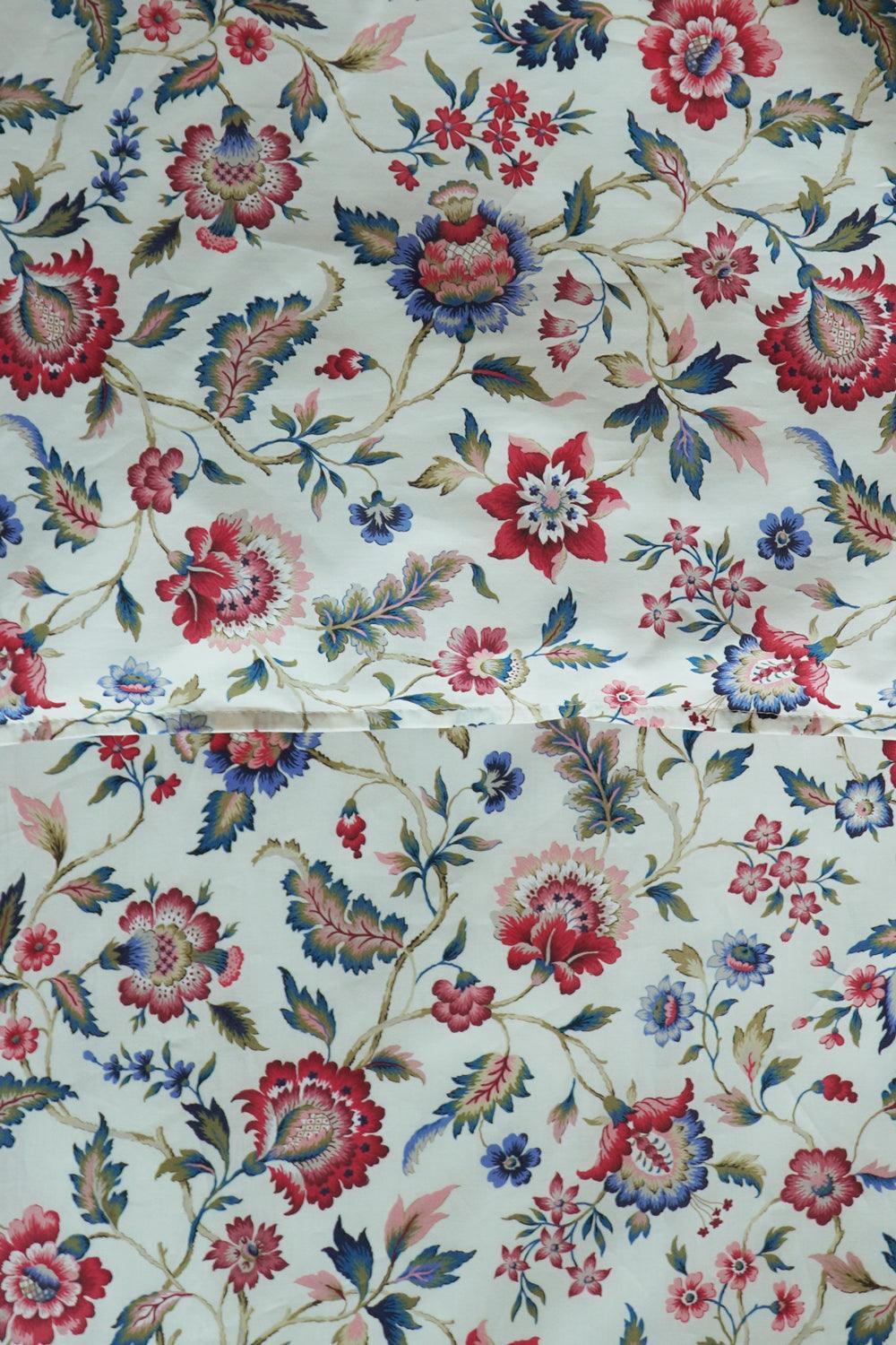 Floral patterned fabric with red, blue, and pink flowers on a white background