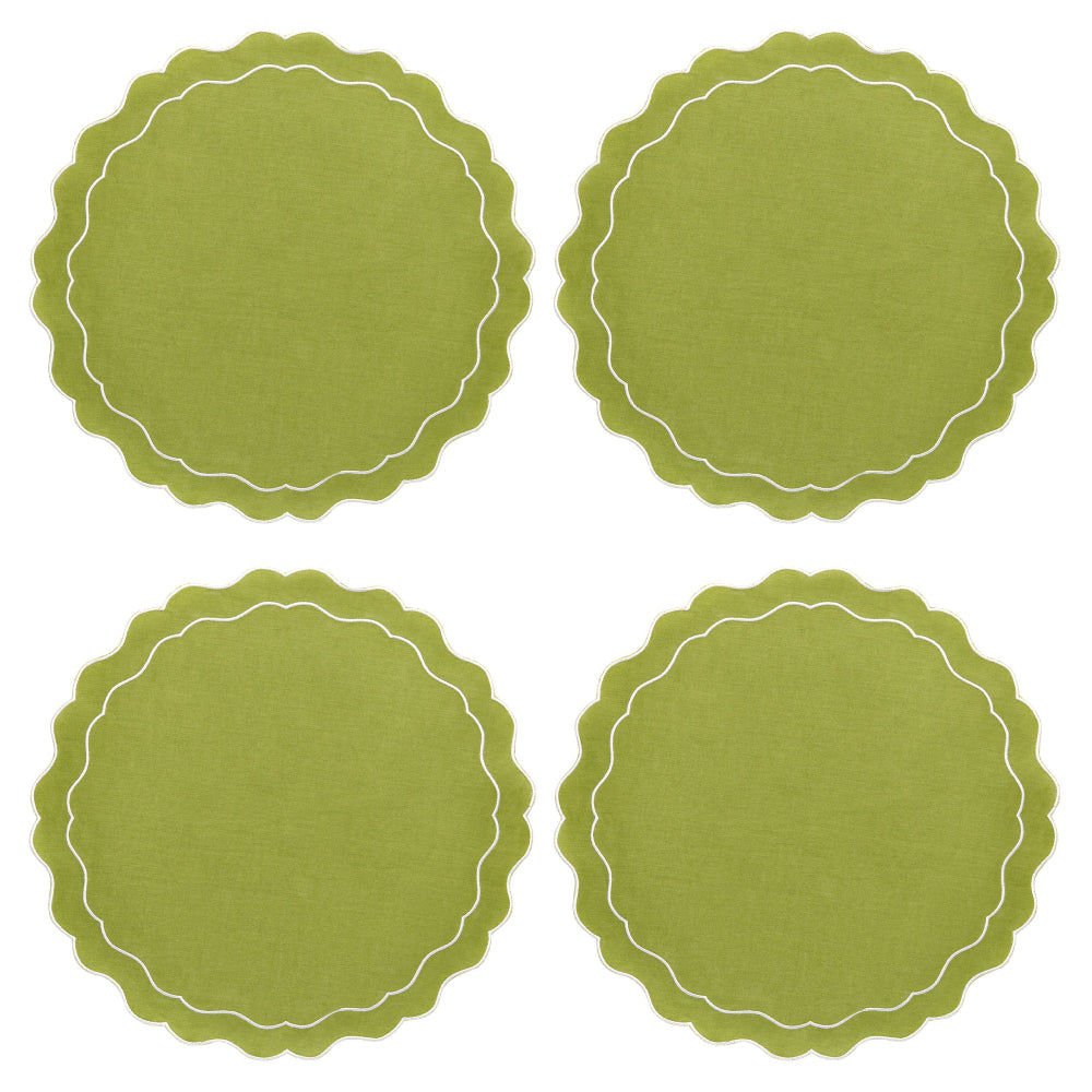 Four green round placemats with white scalloped edges on a white background