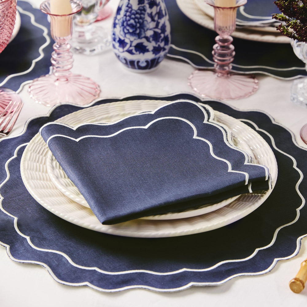 Navy Oxford blue linen napkin on a white plate with decorative navy placemat