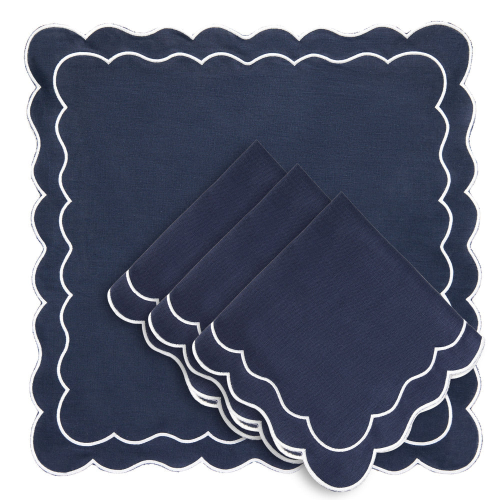 Set of navy blue napkins with scalloped edges on a white background