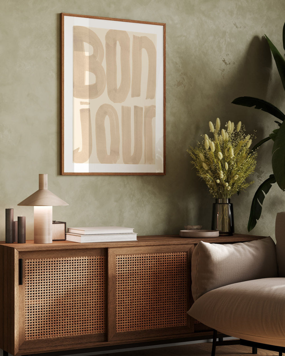 Wooden sideboard with decorative items against a green wall with a framed picture.