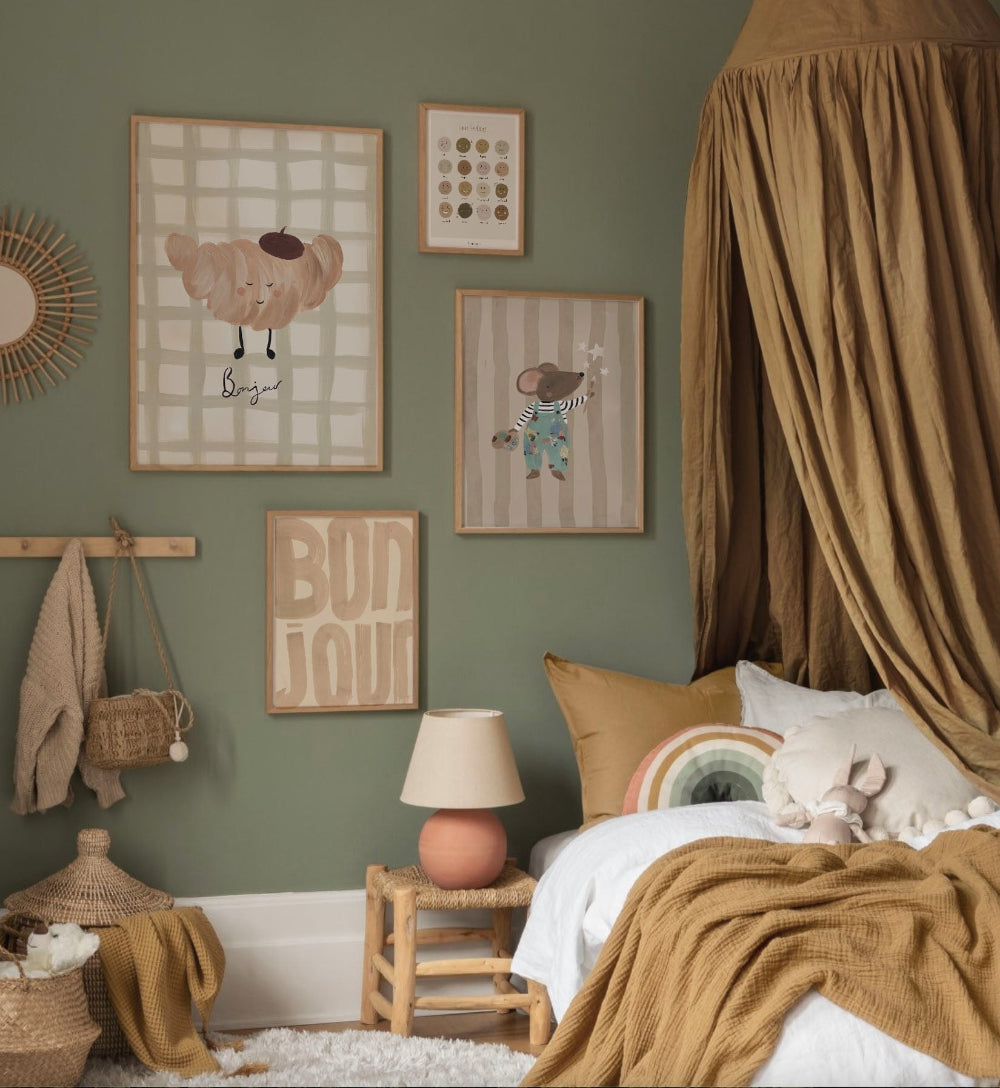 Children's bedroom with green walls, framed artwork, and a bed with brown bedding.
