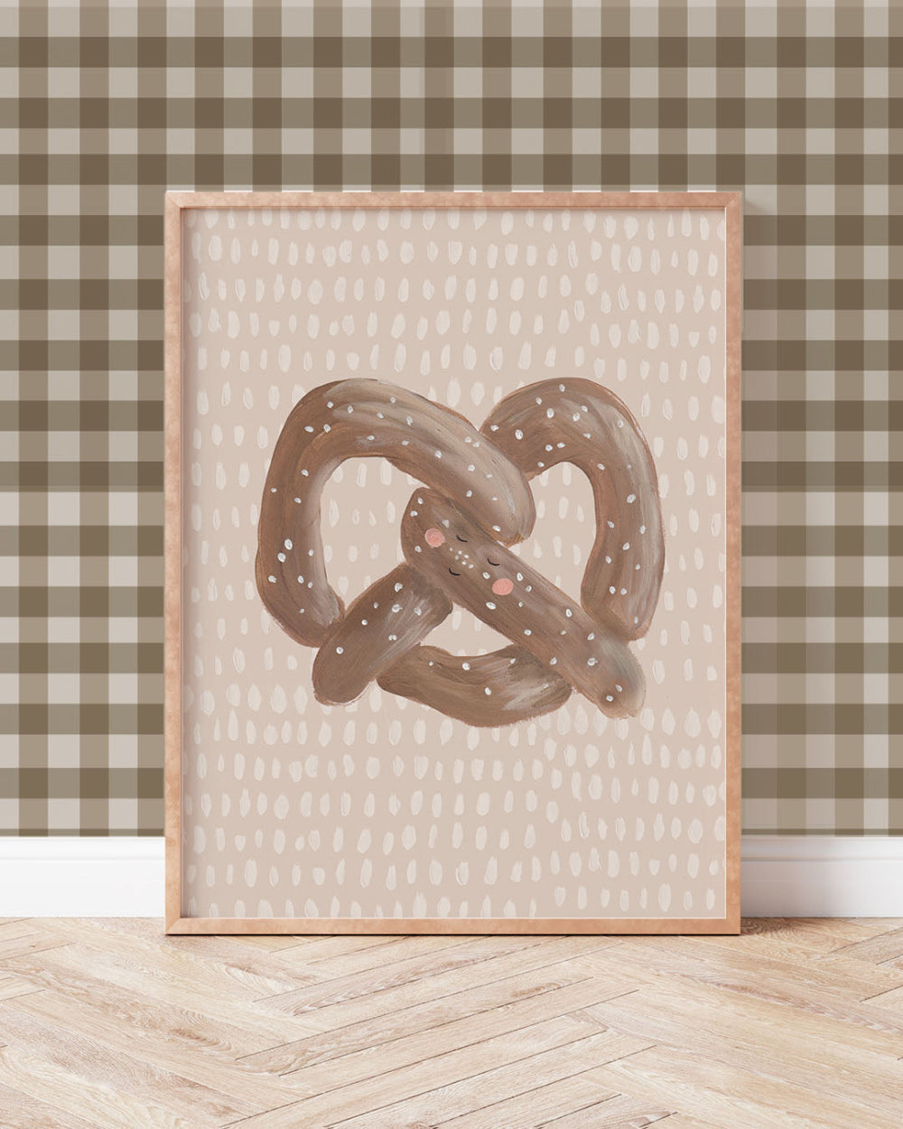 Framed artwork of a pretzel on a wall with a checkered pattern. 'Can you Knot' quote