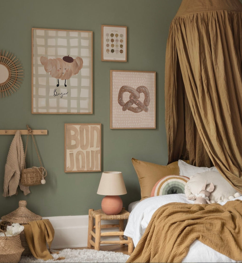 Cozy childrens bedroom with green walls, framed artwork, and a bed with brown bedding.