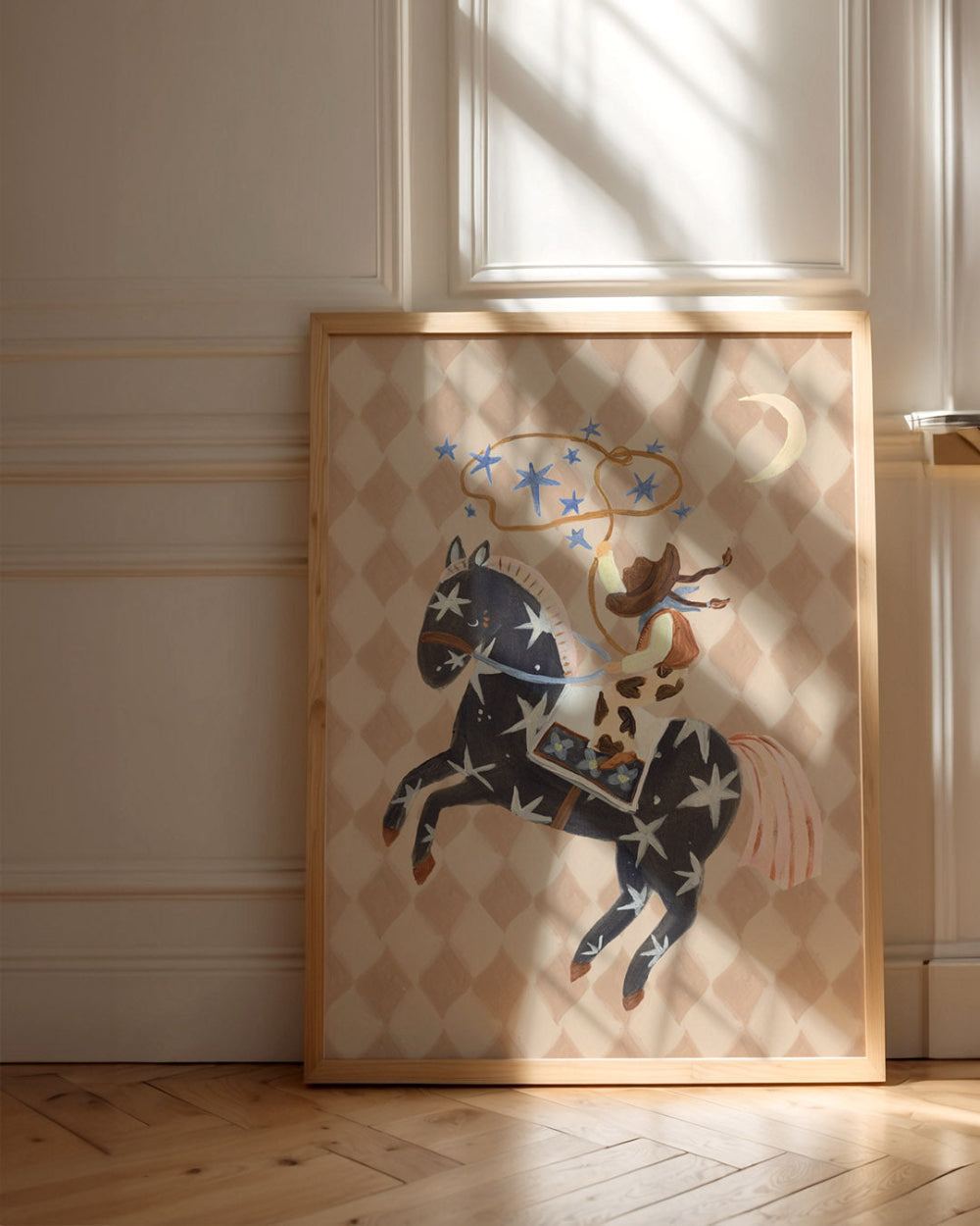 Framed artwork of a cowgirl and horse with star patterns on a wall.