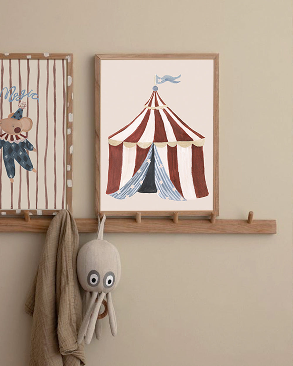 Children's room with framed circus-themed artwork and plush octopus toy on a wooden shelf.