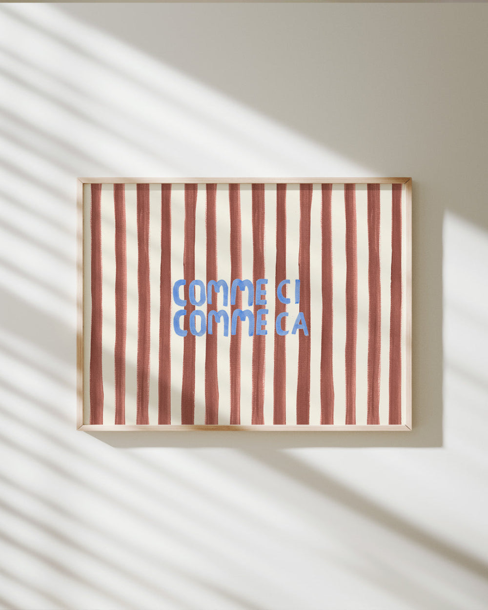 Striped artwork with 'Comme ci, comme ca' text on a light background