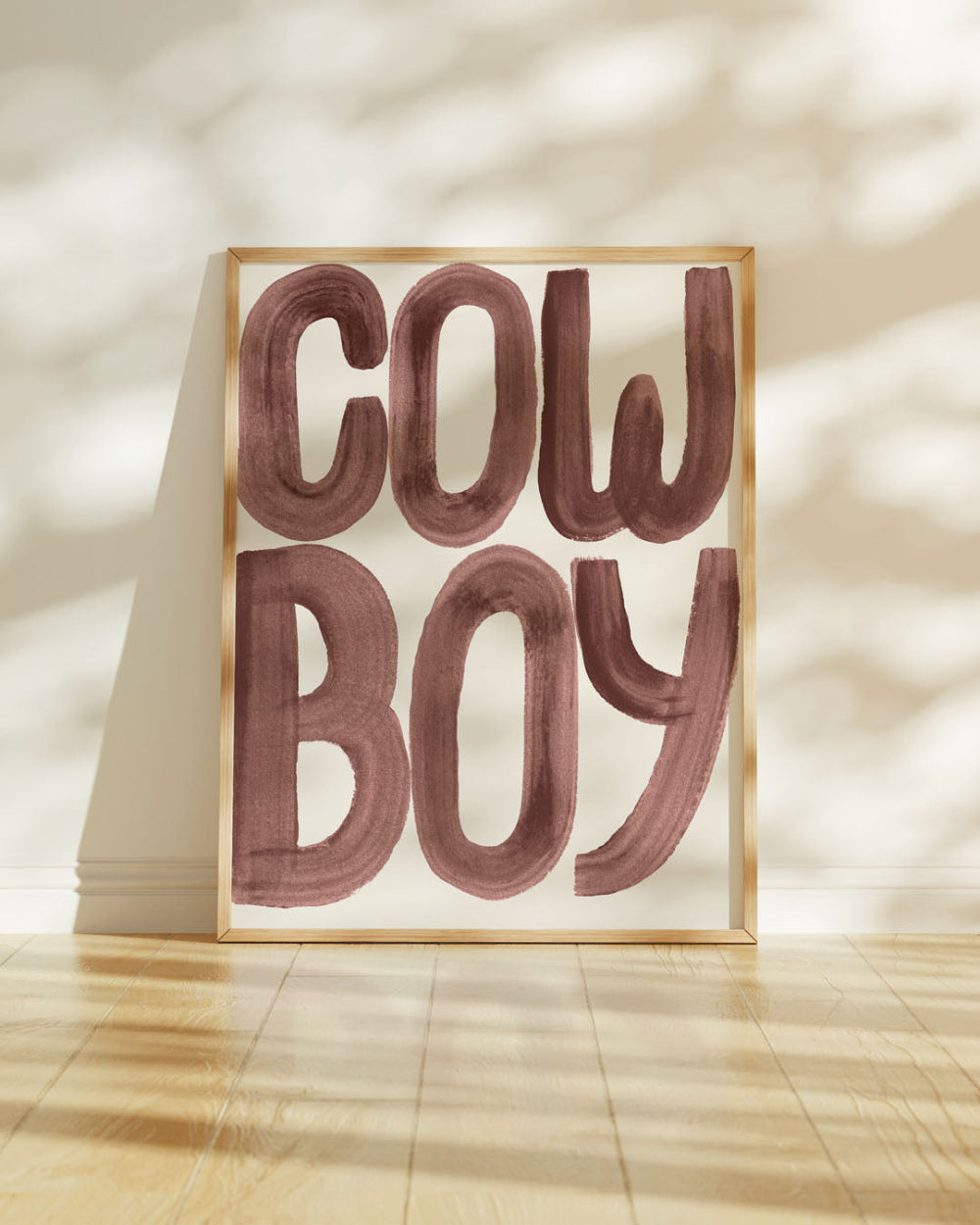 Framed artwork with 'COWBOY' text on a neutral background
