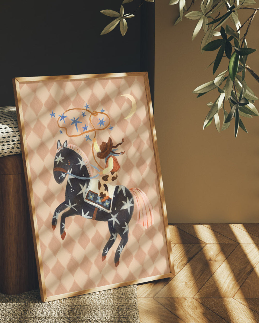 Framed artwork of a horse and girl rider on a patterned background, placed indoors with natural light.