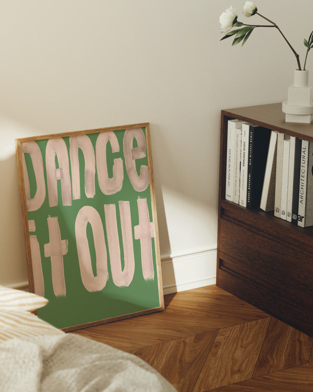 Room interior with a framed poster reading 'Dance It Out' on a wall.