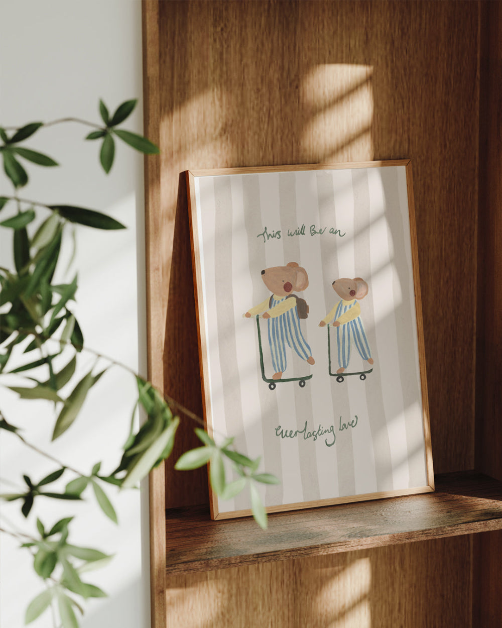 Framed illustration of two mice on skateboards with text, placed on a wooden shelf.