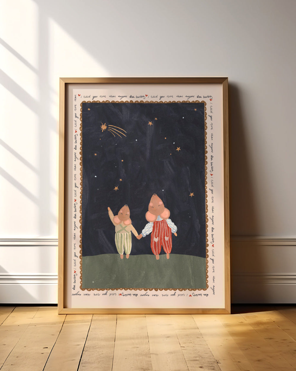 Framed artwork of two mice holding hands under a starry sky on a wall.