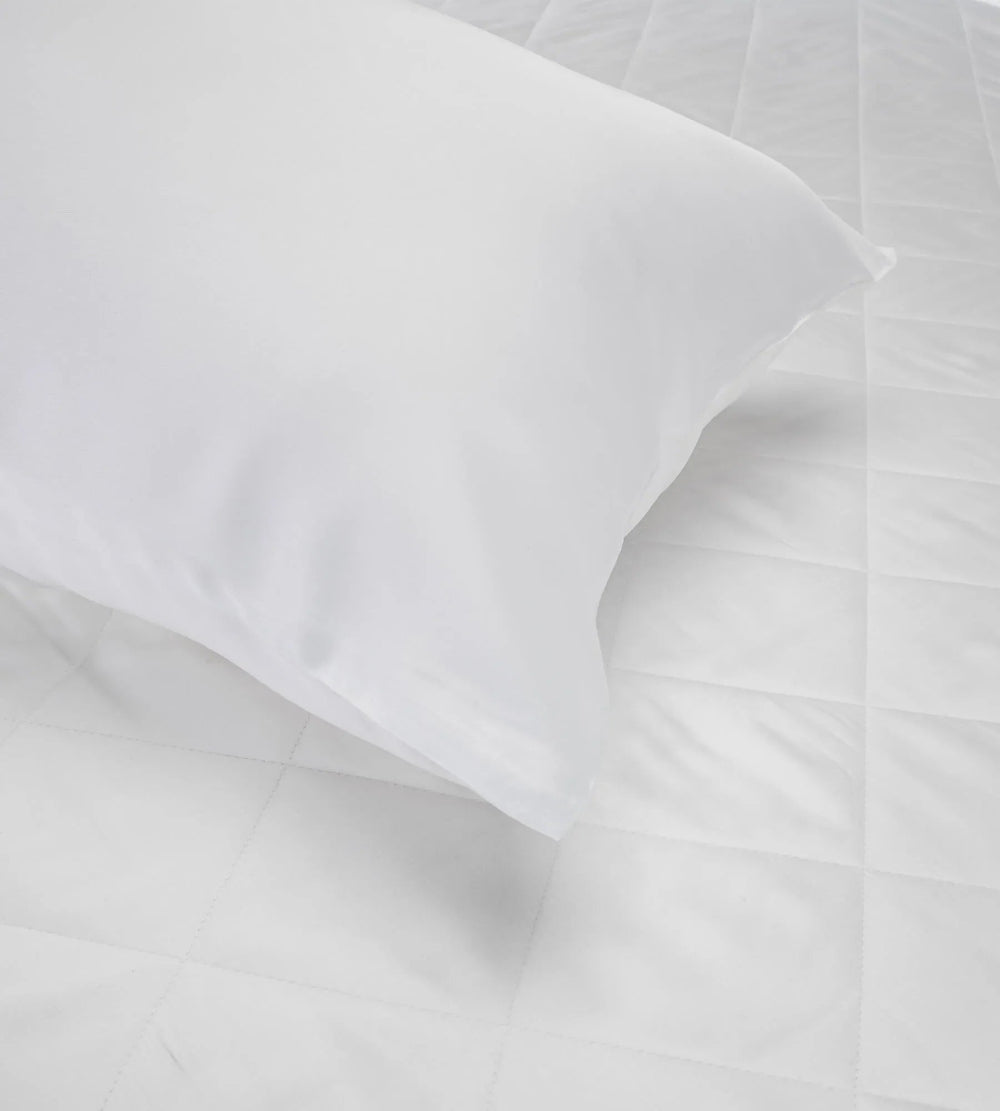 Close-up of white pillow with folds on a light grey background