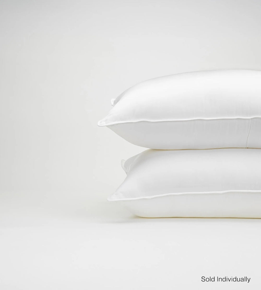 Two white pillows stacked on a light grey background