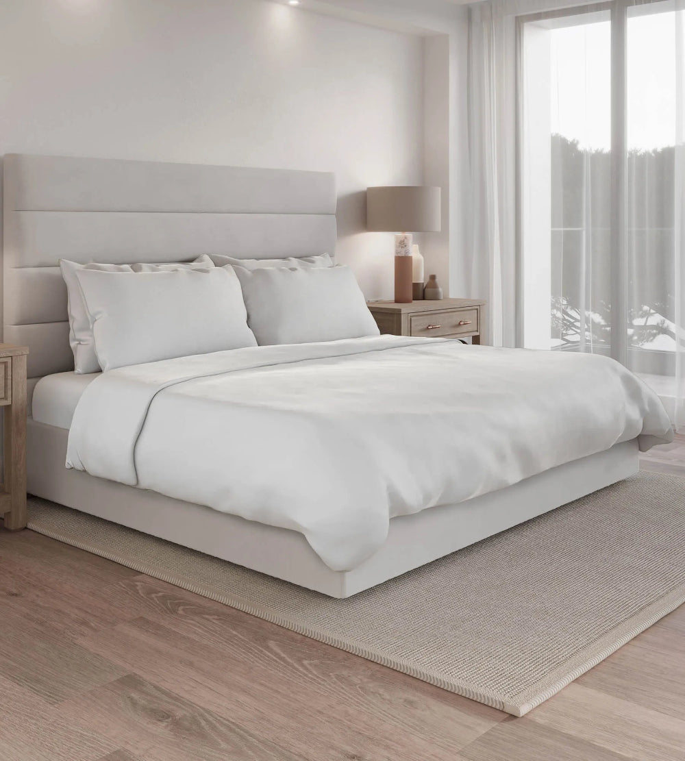 Neatly made bed with white bedding in a modern bedroom.