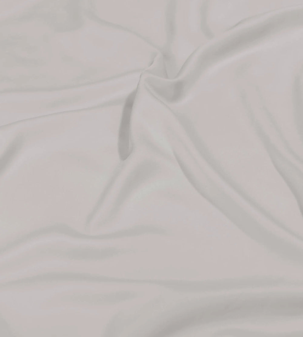 Close-up of light grey bedding bundle sheet with folds
