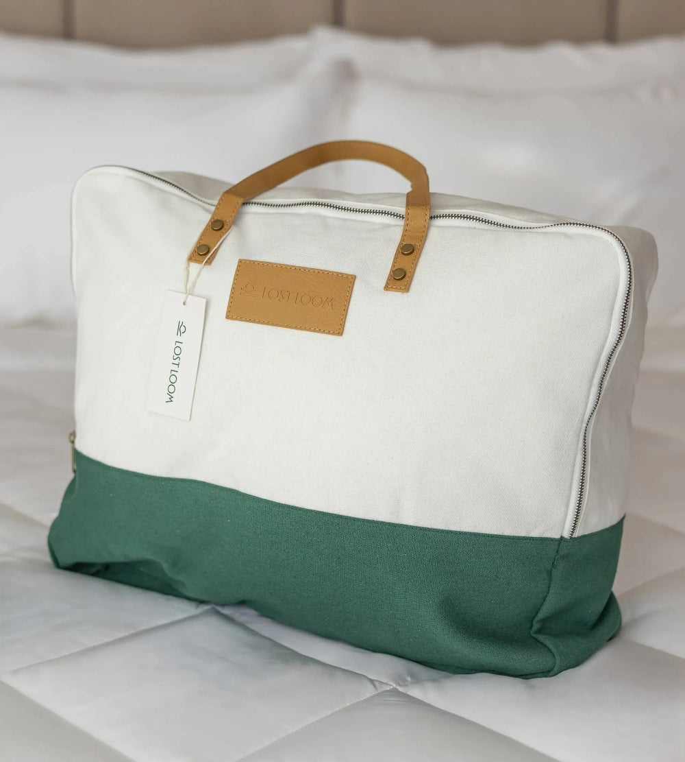 Green and white bag with a brown handle on a bamboo duvet.