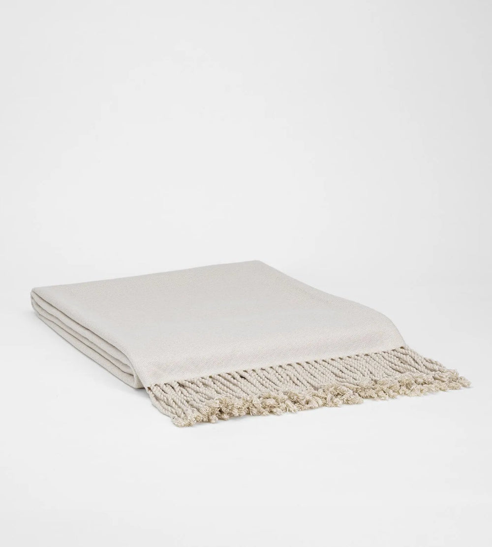 Beige blanket with fringes on a white background